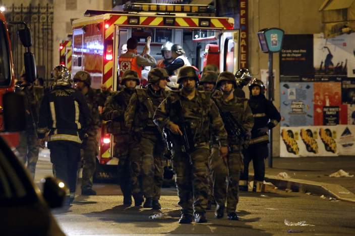 TOPSHOTS Soldiers walk in front of an ambulance as rescue workers evacuate victims near La Belle Equipe, rue de Charonne, at the site of an attack on Paris on November 14, 2015 after a series of gun attacks occurred across Paris as well as explosions outside the national stadium where France was hosting Germany. More than 100 people were killed in a mass hostage-taking at a Paris concert hall and many more were feared dead in a series of bombings and shootings, as France declared a national state of emergency. AFP PHOTO / PIERRE CONSTANTPIERRE CONSTANT/AFP/Getty Images